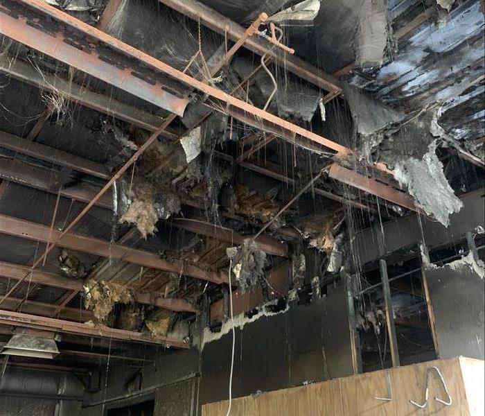 Burnt-out, smoked-damaged ceiling with soot "spiderwebbing" hanging down